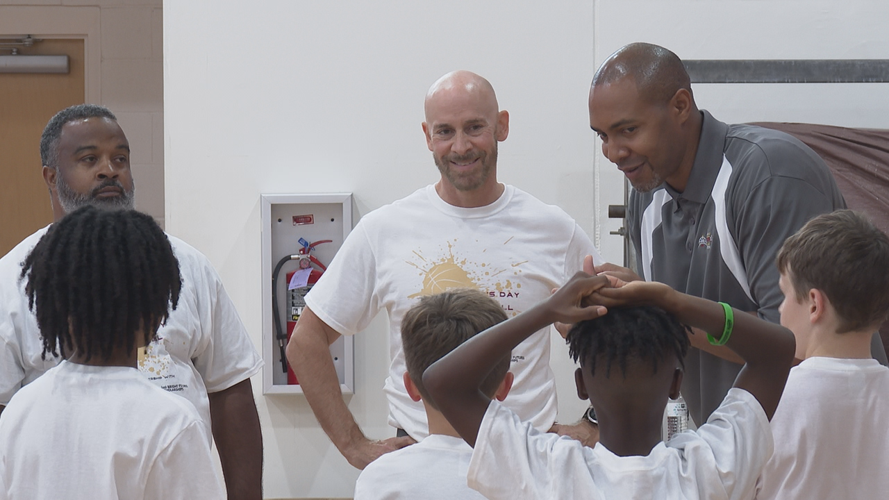 Charlie talking with men and boys at the basketball clinic